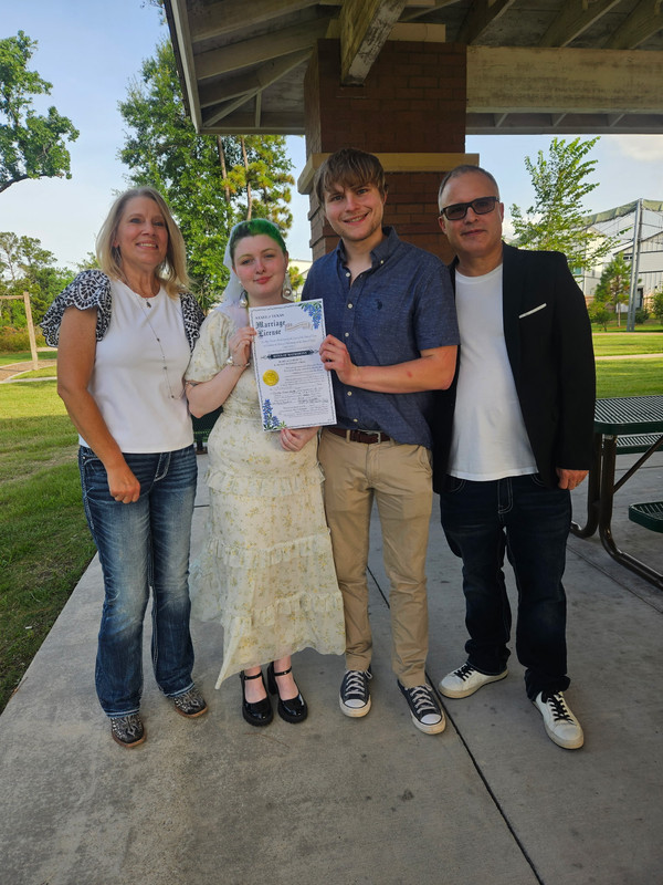 A newly married couple with their officiant and family after their Texas ceremony.